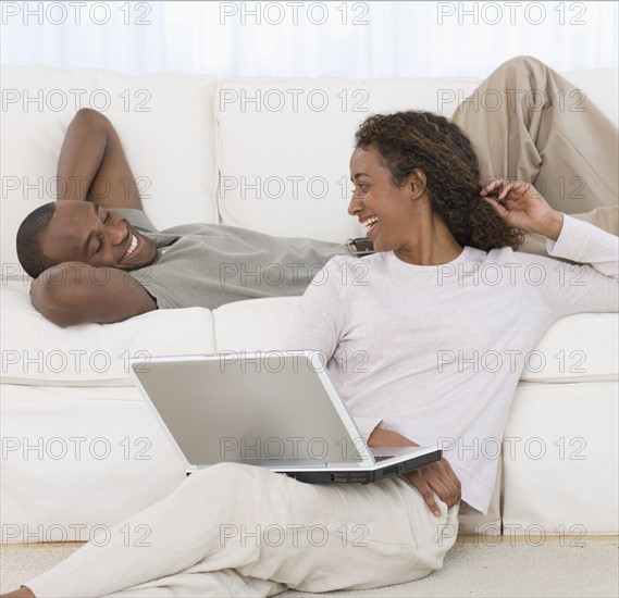 Couple smiling at each other in livingroom.