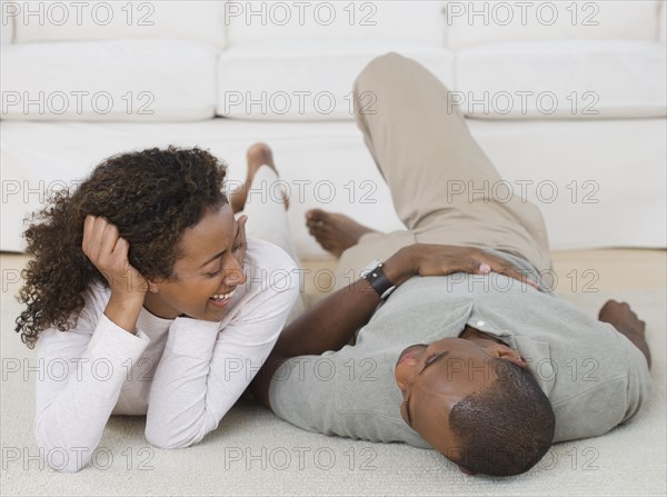 Couple smiling at each other in livingroom.