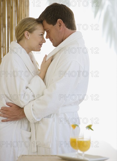 Couple in bathrobes hugging.