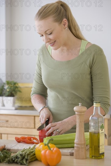 Woman chopping vegetables in kitchen.