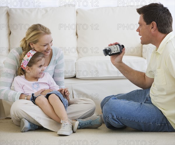 Father video recording mother and daughter.