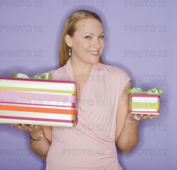 Woman holding big and small gifts.