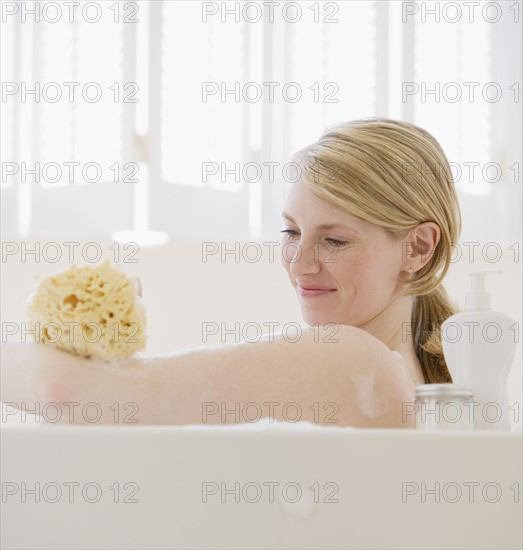 Woman washing in bathtub.