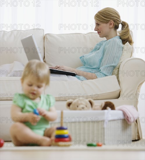 Mother and baby relaxing in living room.