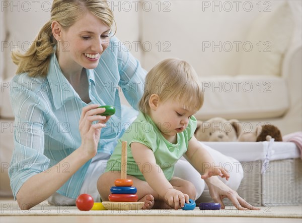 Mother and baby playing on floor.