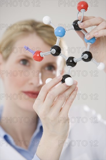 Female scientist looking at molecule model.
