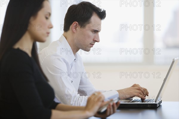 Businesspeople working at table.