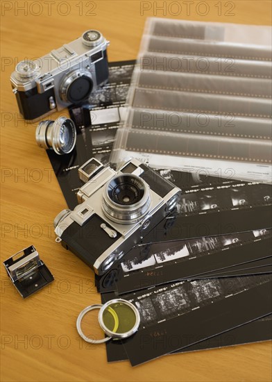 Cameras, negatives and contact sheets on table.