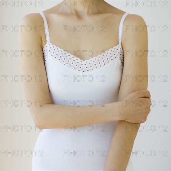 Woman with arm crossed over torso.