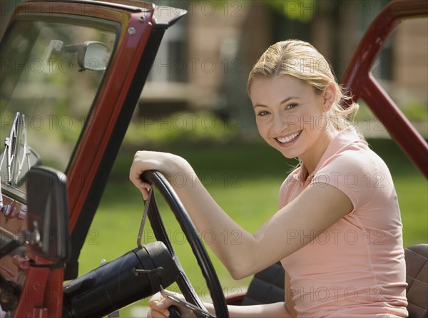 Woman sitting in jeep.