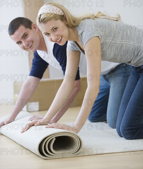 Couple unrolling rug.