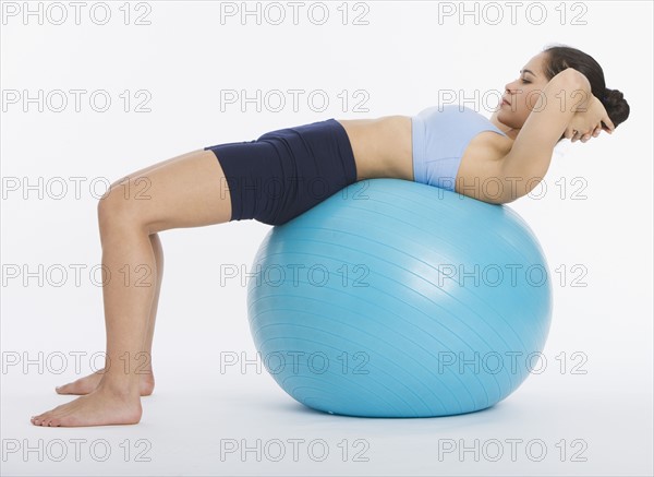 Woman doing crunches on exercise ball.