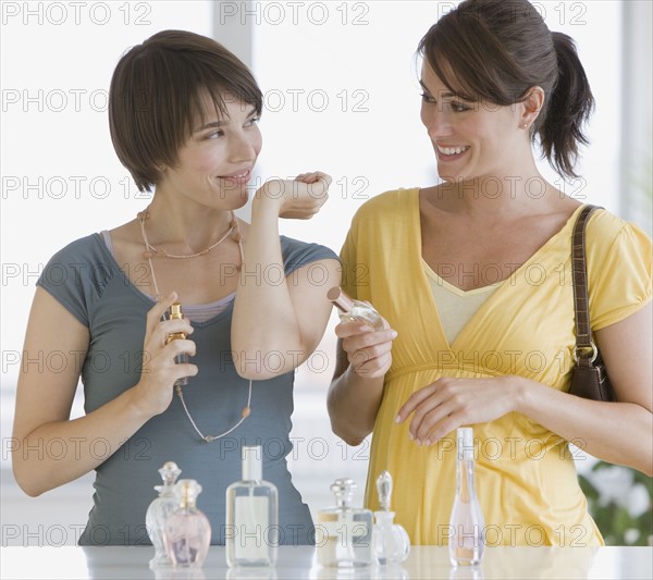 Two women trying perfumes.