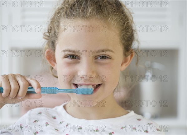 Girl brushing teeth.