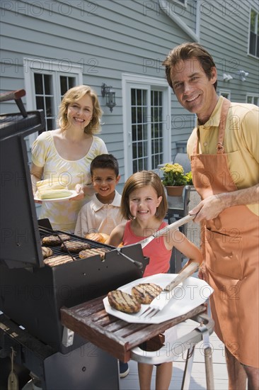 Family barbequing on deck.