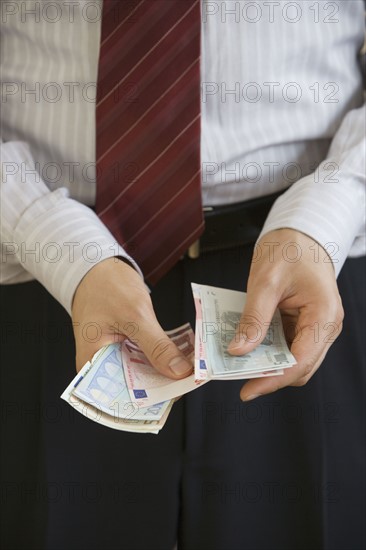 Businessman counting Euro banknotes.