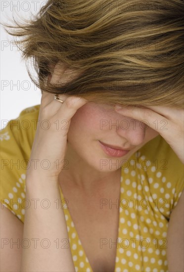 Close up of woman with head in hand.