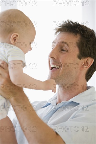 Father and baby smiling at each other.