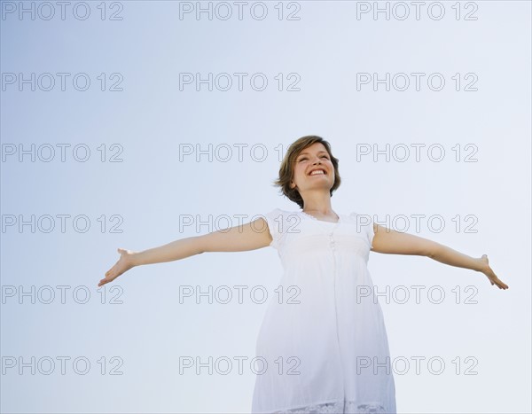 Low angle view of woman with arms outstretched.