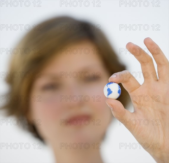 Woman holding tiny globe.