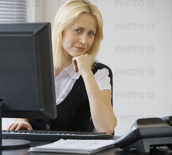 Businesswoman sitting at desk.
