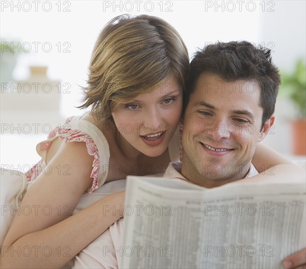 Couple reading newspaper.