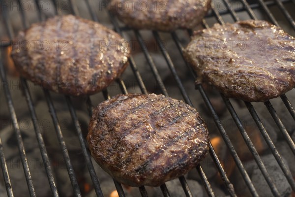 Hamburgers cooking on grill.