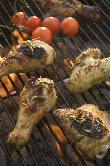 Chicken pieces cooking on grill.