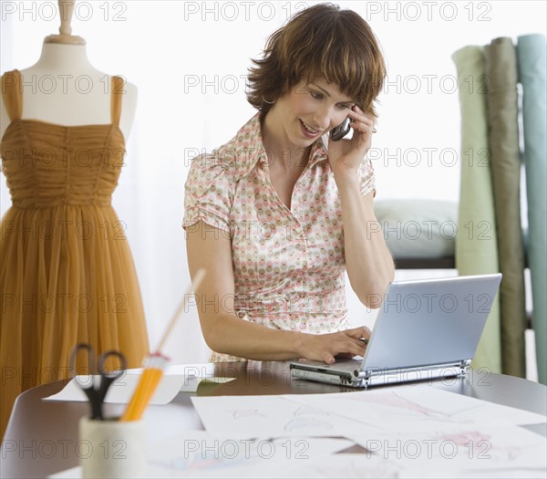 Female clothing designer talking on cell phone.