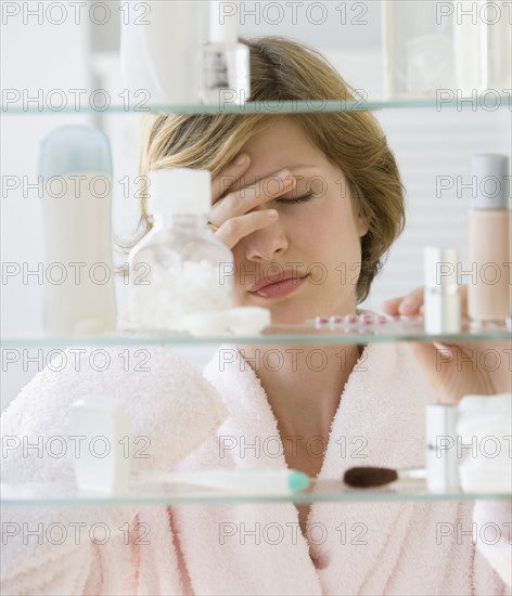 Woman looking in medicine cabinet.