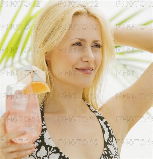 Woman holding tropical cocktail.