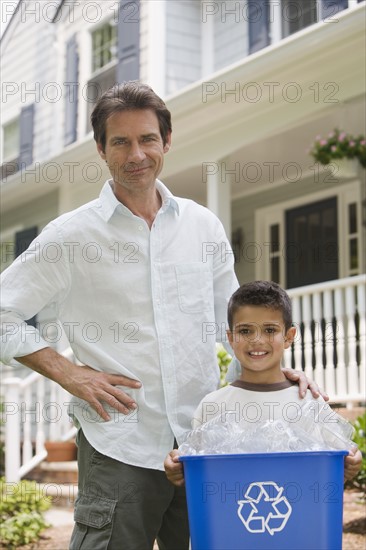 Father and son with recycling bin.