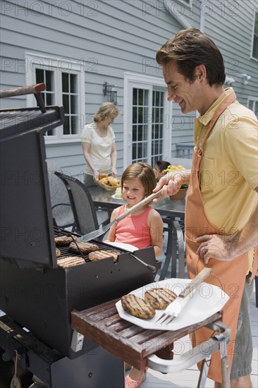 Family barbequing on deck.