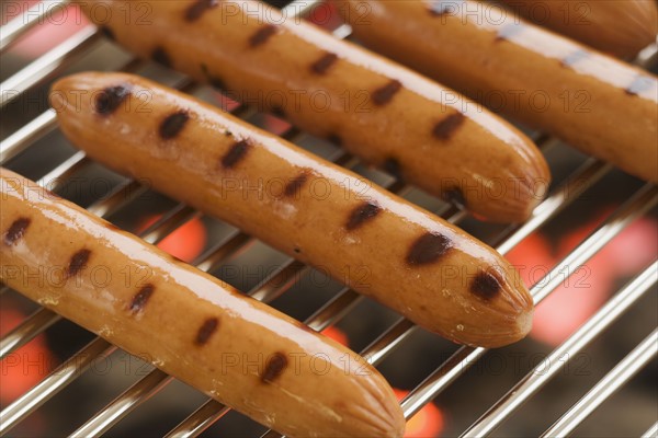 Hot dogs cooking on grill.