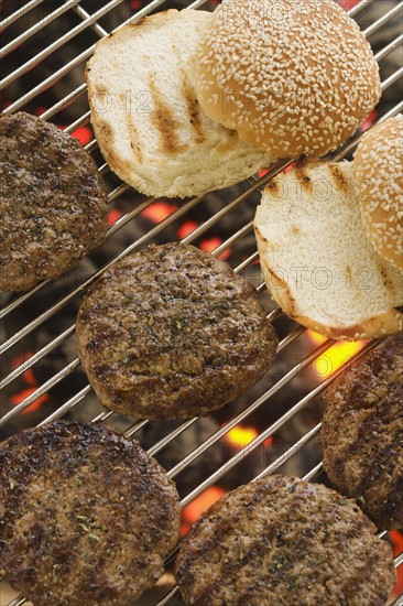 Hamburgers cooking on grill.