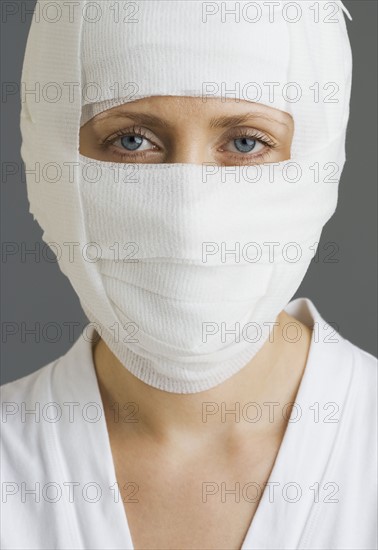 Woman’s face wrapped in bandages.