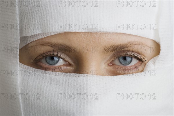 Woman’s face wrapped in bandages.