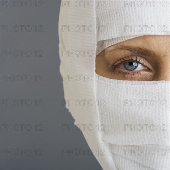 Woman’s face wrapped in bandages.