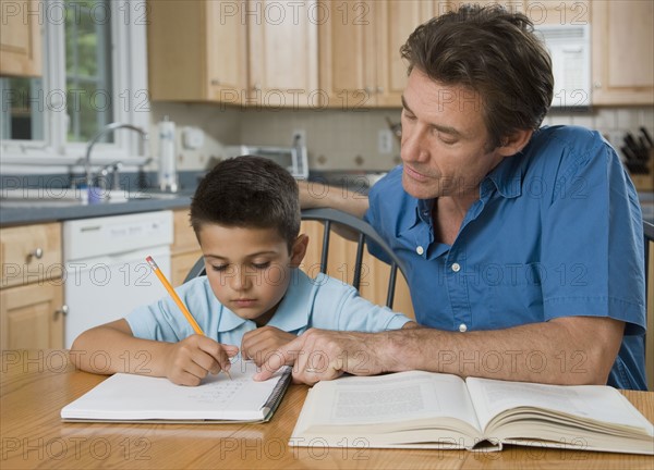 Father helping son with homework.