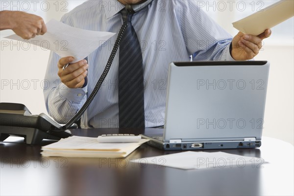 Busy businessman at desk.