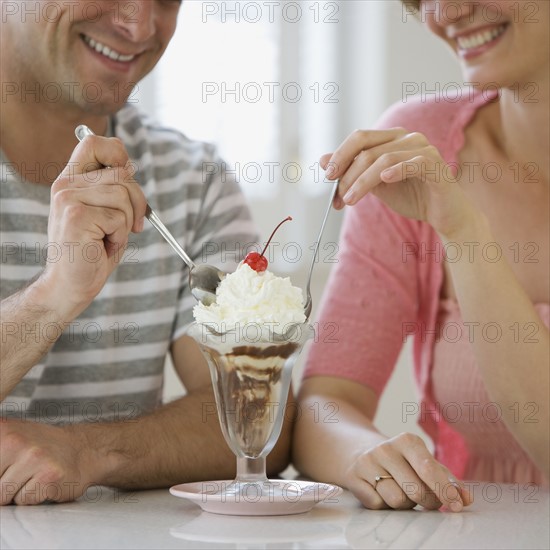 Couple sharing ice cream sundae.