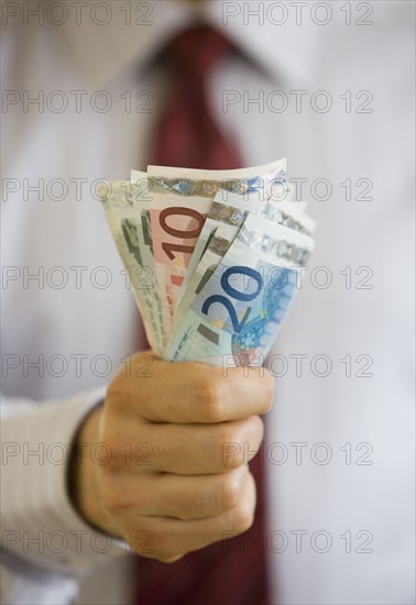 Businessman holding Euro banknotes.