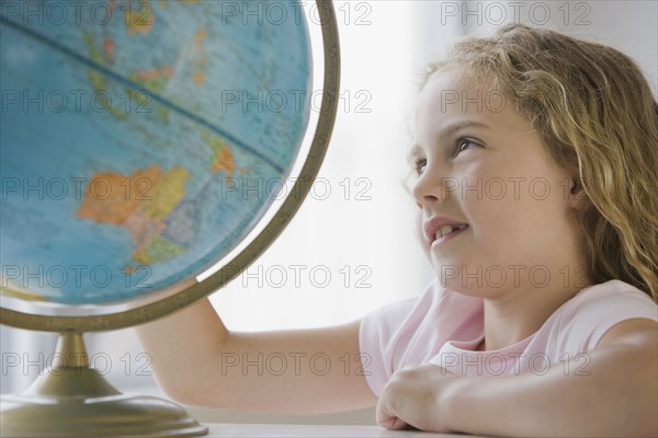 Girl looking at globe.