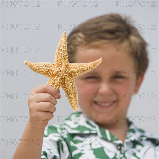 Boy holding starfish.