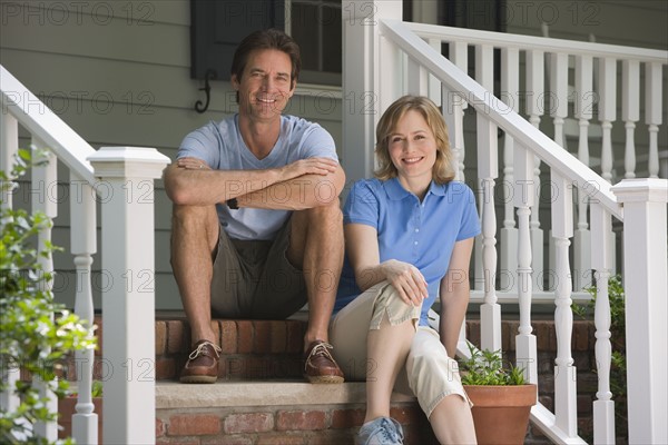 Couple sitting on porch steps.