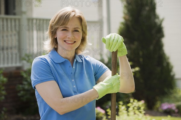 Woman wearing gardening gloves outdoors.