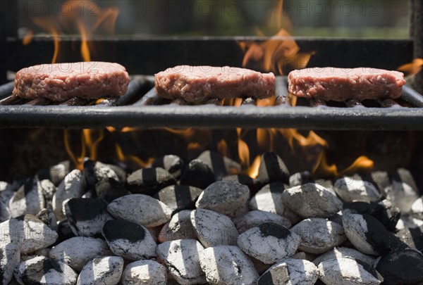 Hamburgers cooking on grill.