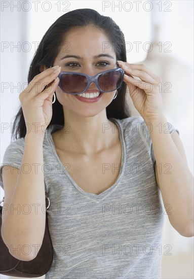 Woman putting on sunglasses.