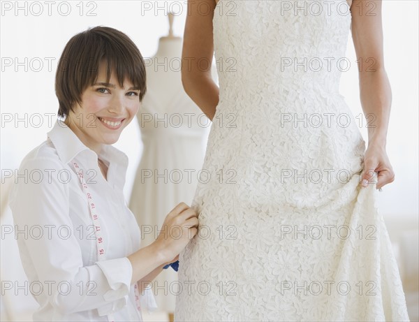 Bride having dress fitted.