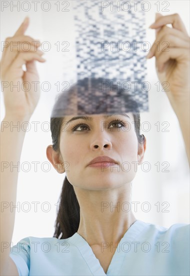 Female doctor looking at DNA sheet.